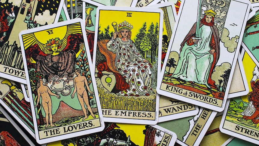 A close up of tarot cards showing the lovers, the empress and king of swords.