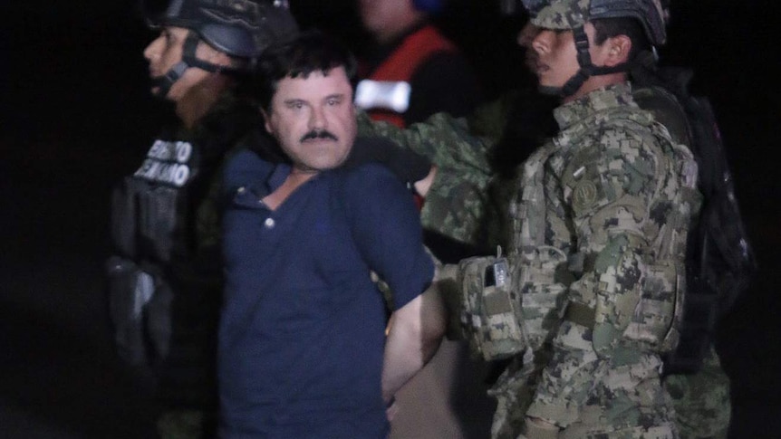 Drug kingpin Joaquin "El Chapo" Guzman is escorted by marines to a helicopter at Mexico City's airport