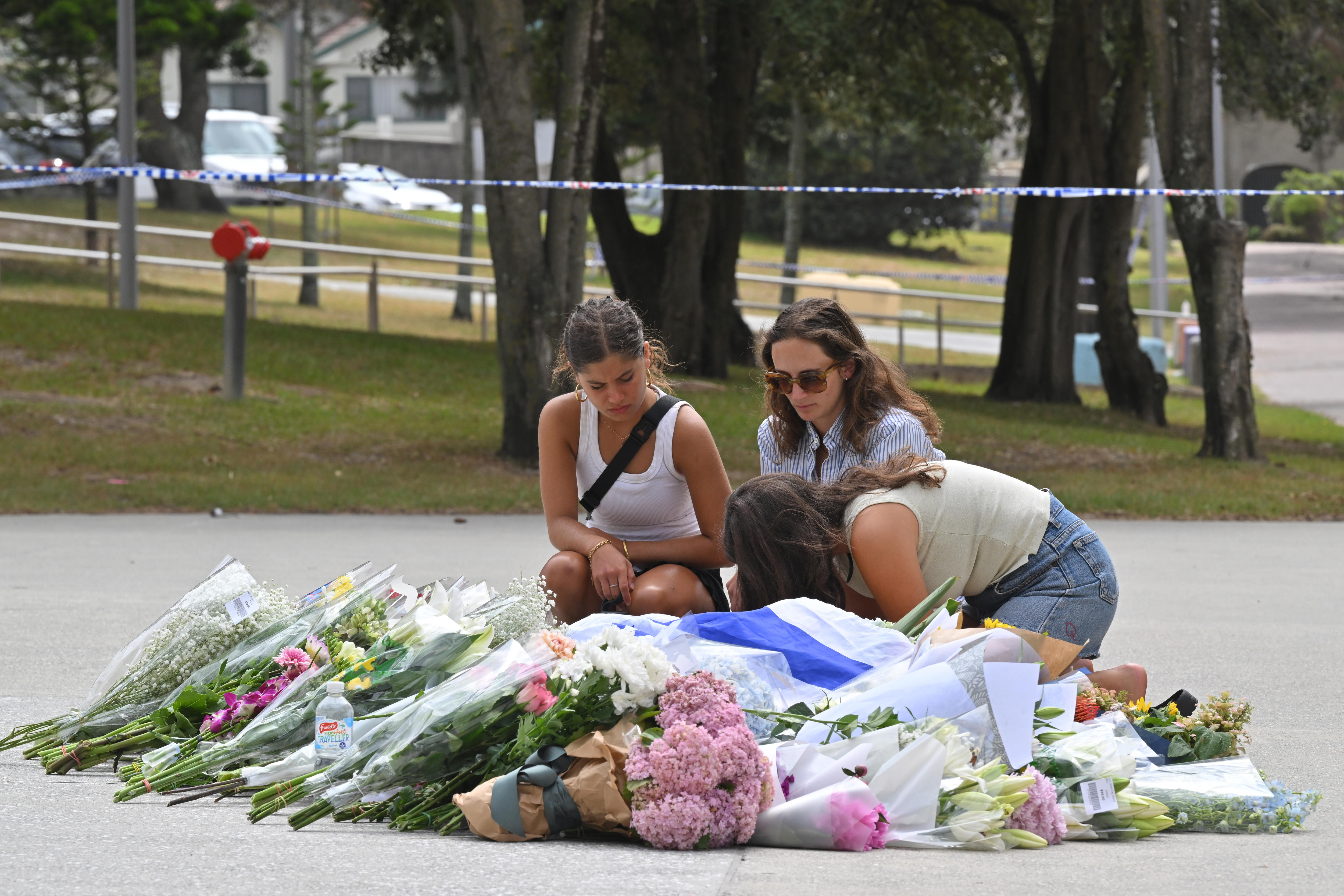 Mujeres reunidas sobre flores en el suelo.