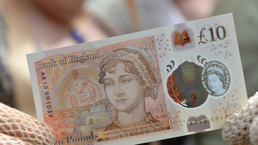 People in period costume pose with the new 10 pound note featuring Jane Austen