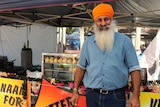 John Arkan standing in front of the food stall he operates each week at the Coffs Harbour Produce Markets.