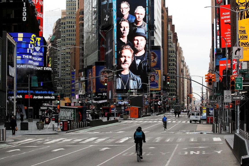 Cyclists ride through a nearly empty Times Square.