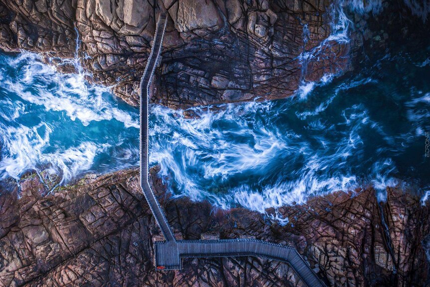 A birds-eye view shows the rushing rapids at Canal Rocks and a bridge between the cliffs