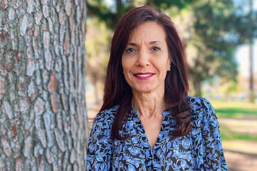 Adele Farina in colourful blouse next to tree