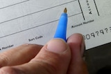 A close up of someone writing on a blank cheque