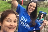 Elle Provost wearing a blue shirt with a campaign staffer in front of a marquee