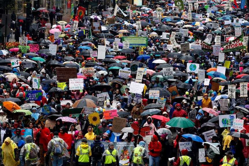 Demonstrators in Chicago march against Mr Trump's climate policies and his actions during his first 100 days in office.