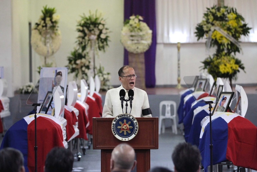 Philippine President Benigno Aquino delivers a speech in front of the caskets of the slain members of the Special Action Force