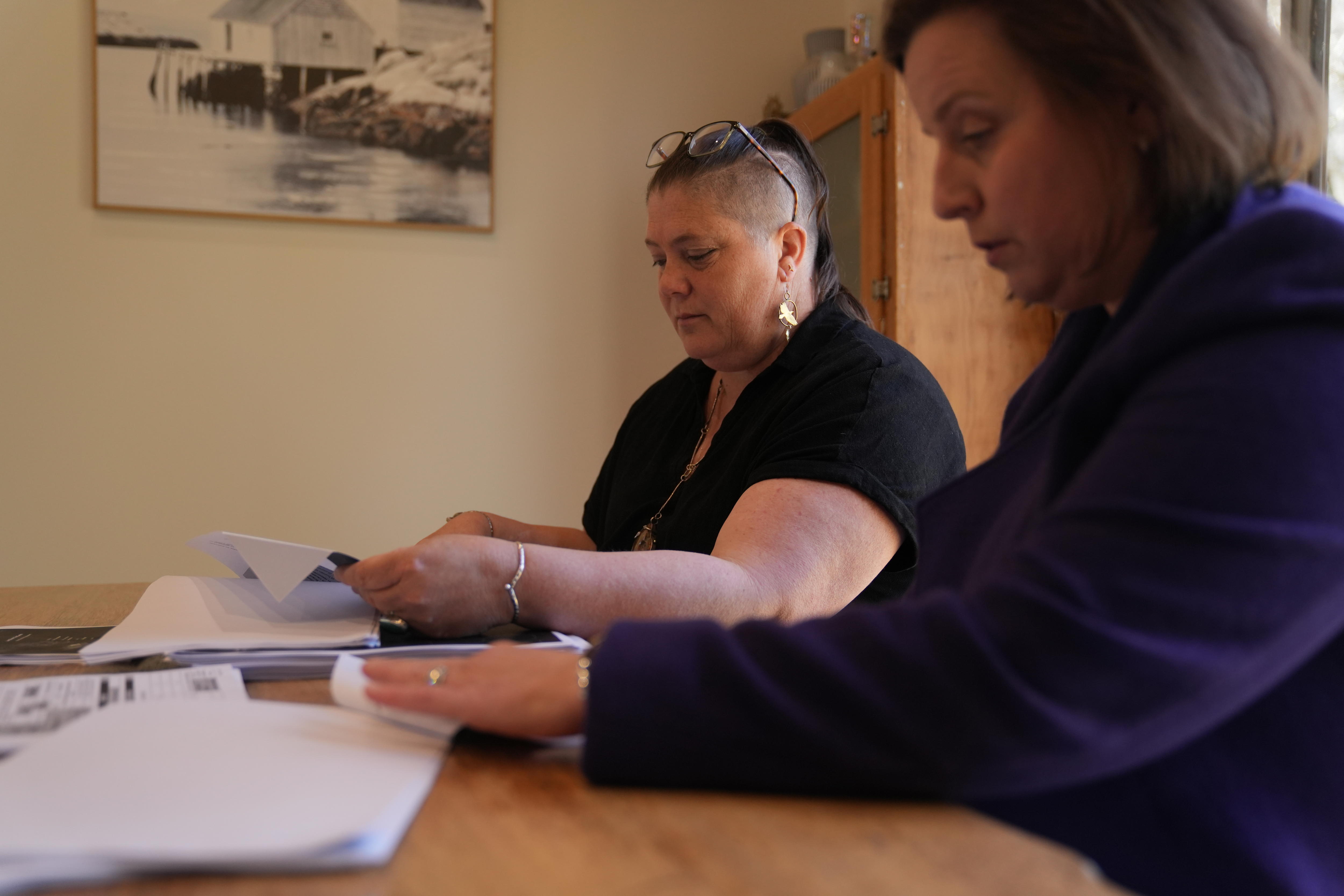 The pair are pictured side on looking through documents at the table. Ms Thompson is in focus.