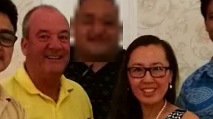 A man in yellow shirt and a woman with glasses, both smiling.