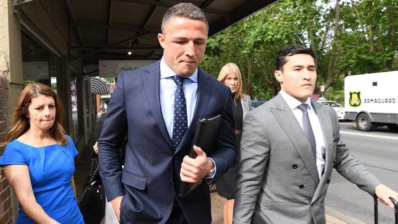 Sam Burgess in a suit arriving at court.