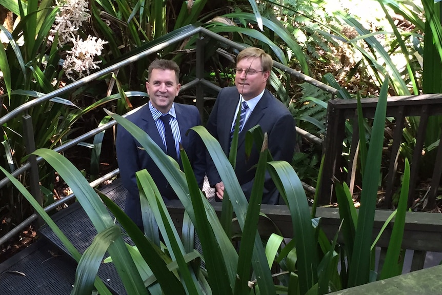 Craig Connelly and Peter Byron pose in a rainforest area.