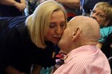 The Northern Territory's new Administrator Vicki O'Halloran gets a peck on the cheek from a man in a wheelchair.
