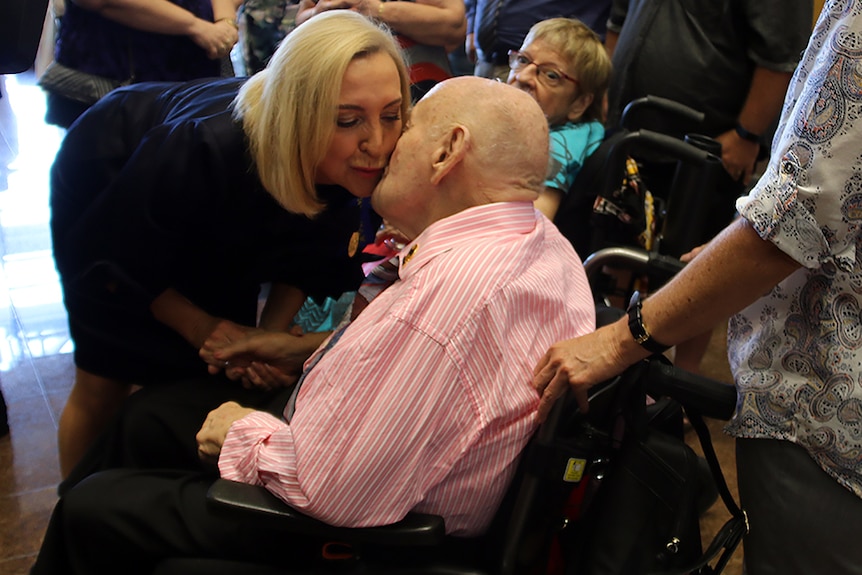 The Northern Territory's new Administrator Vicki O'Halloran gets a peck on the cheek from a man in a wheelchair.