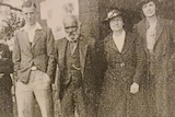 An old black and white photo of five people standing in a row.