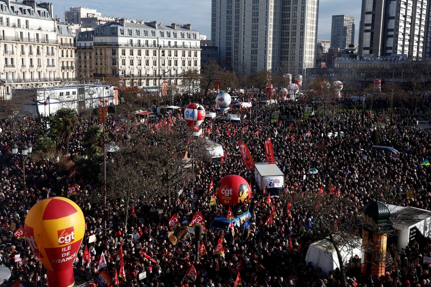 Thousands of protesters clad in red occupy a square.