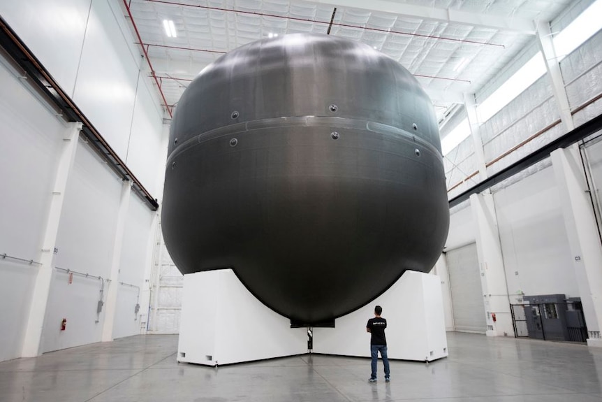 A man looks at the first development tank for SpaceX's Mars spaceship.