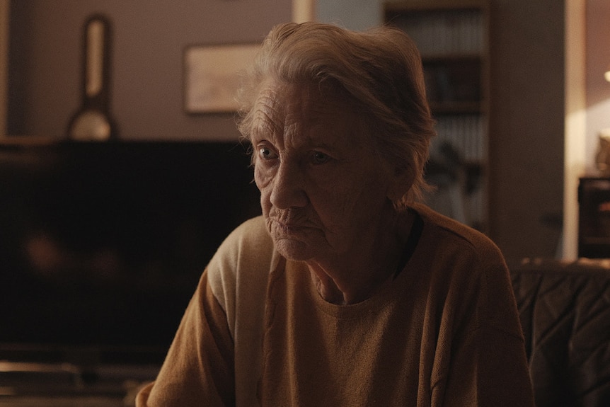 An older woman in a living room in the film The Trouble with Being Born