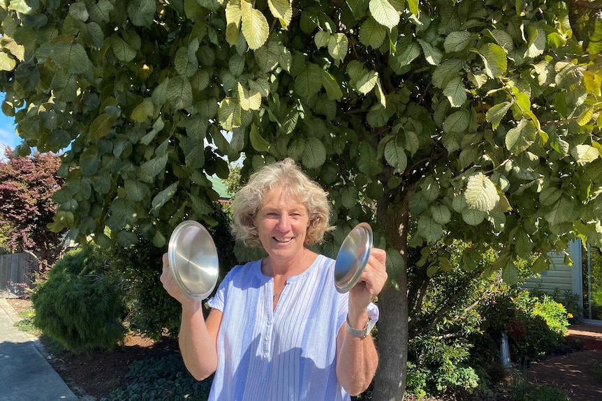 Jean Petterwood holds up lids of a saucepan.