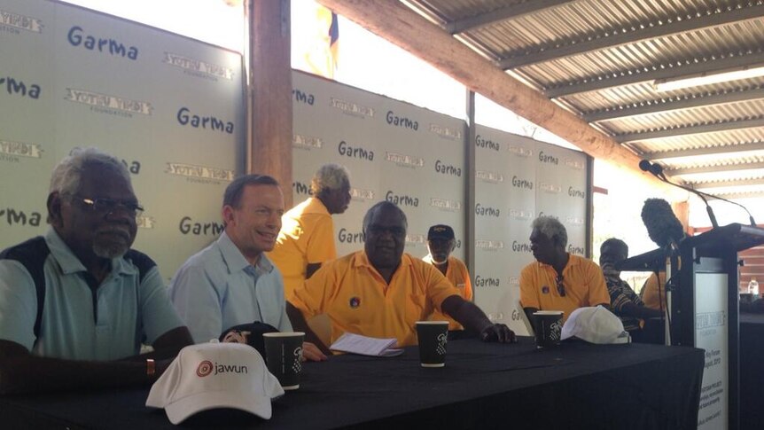 Galarrwuy Yunupingu sits with Tony Abbott and other speakers at Garma festival in Arnhem Land.