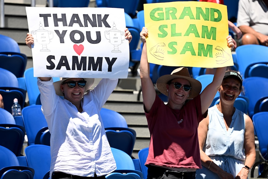 Two spectators hold up signs supporting Sam Stosur at the Australian Open.