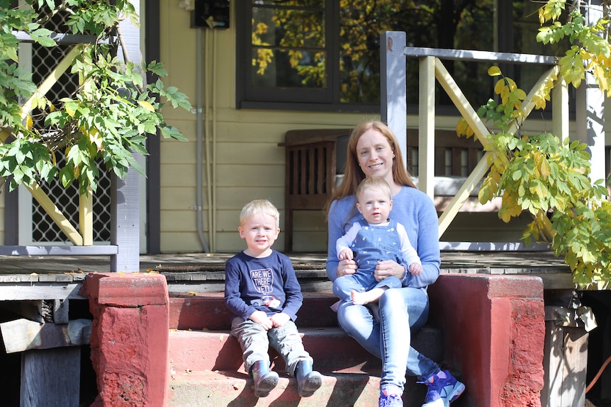Heather Shaw and her children sitting on the front steps of their house