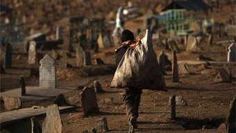 Yar Mohamad, 9, walks through a cemetery while collecting metals for money February 1, 2010 in Kabul, Afghanistan (Spencer Pl...