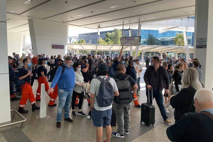 A crowd at Adelaide Airport amid an incident.