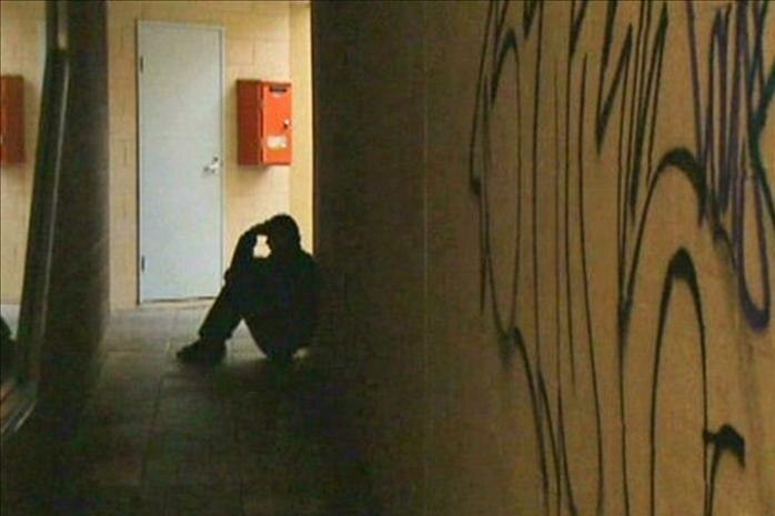 A man sits in the shadows in a hallway (ABC News)