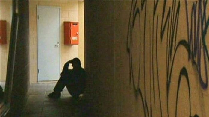 A man sits in the shadows in a hallway (ABC News)