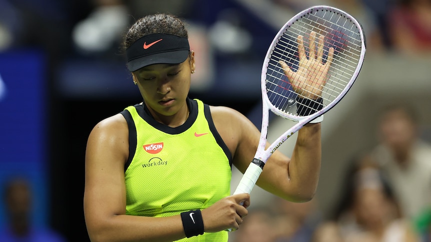 Women with her tennis racket looking disappointed during a match