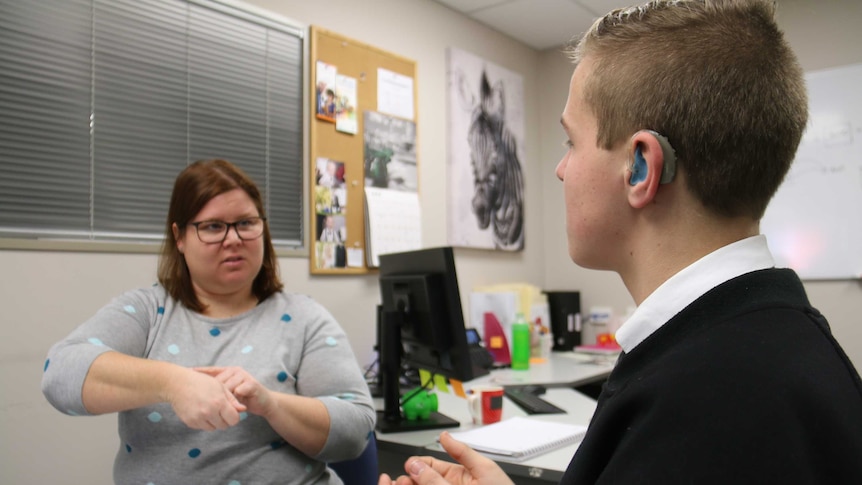 Brenton Peters and Deaf Can: Do's Debbie Kennew sit at a desk