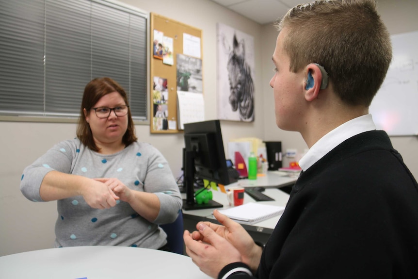 Brenton Peters and Deaf Can: Do's Debbie Kennew sit at a desk