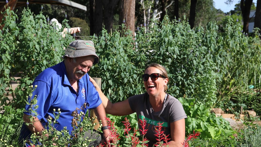 A man and woman laughing in the Lost Plot community garden.