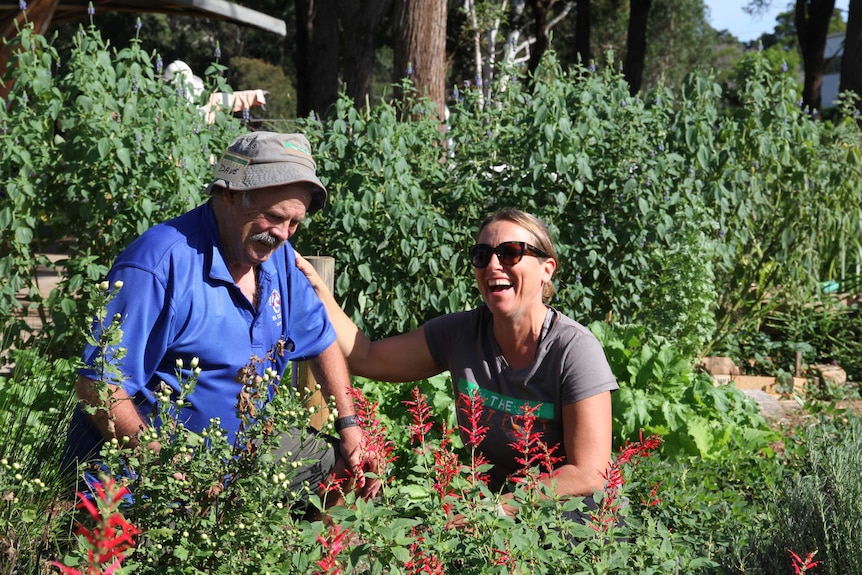 A man and woman laughing in the Lost Plot community garden.