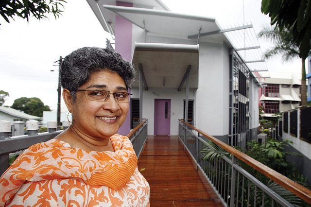 An Indo-Fijian woman with short grey hair smiles outisde a building in Fiji