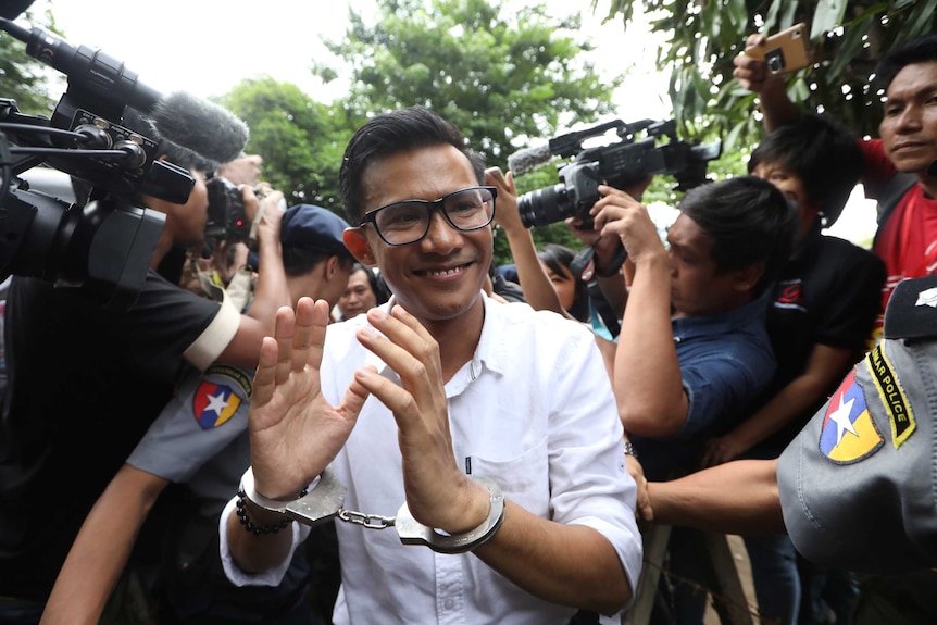 Eleven Media editor Kyaw Zaw Linn arrives at a Yangon court in handcuffs.