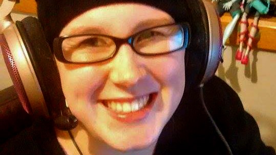 Hannah Morrison wears headphones and smiles while playing video games at home