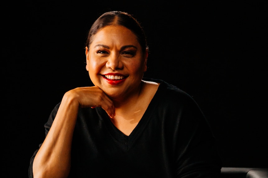 photo of deb mailman smiling and sitting down wearing a black top
