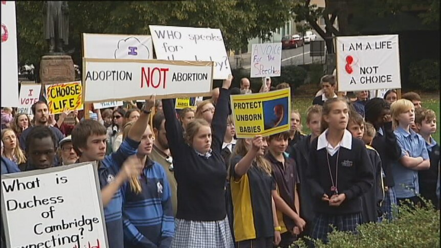 School children hold anti-abortion placards outside Tasmania's parliament.