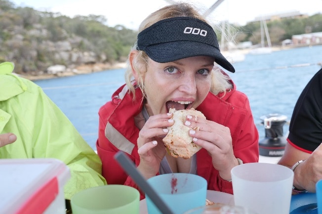 Nicole Rothacker eats a meal seated on a yacht on Sydney Harbour.