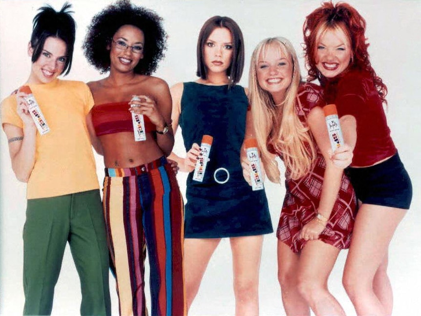 The Spice Girls (Mel C, Mel B, Victoria, Emma and Geri) pose together holding Impulse body spray cans towards the camera