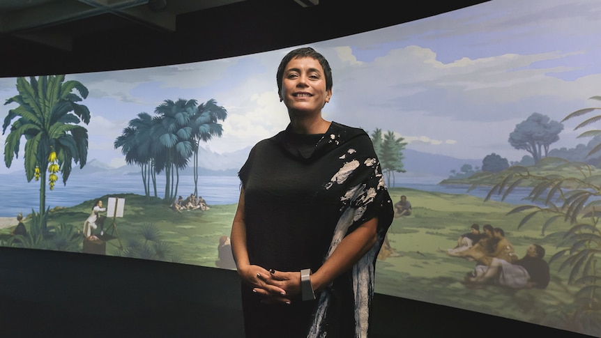 Artist Lisa Reihana stands in front of her panoramic digital artwork 'In Pursuit of Venus [Infected]'.