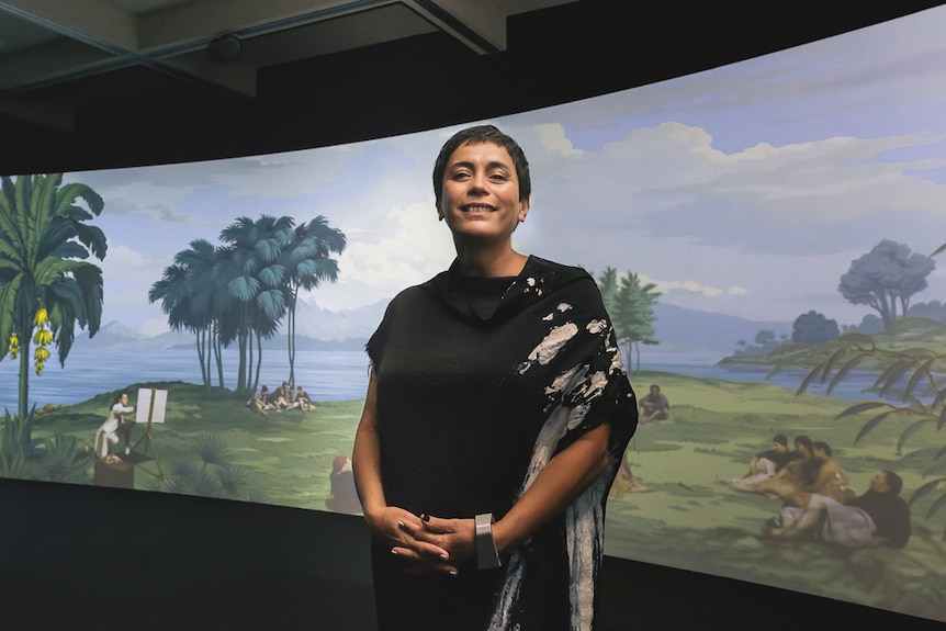 Artist Lisa Reihana stands in front of her panoramic digital artwork 'In Pursuit of Venus [Infected]'.