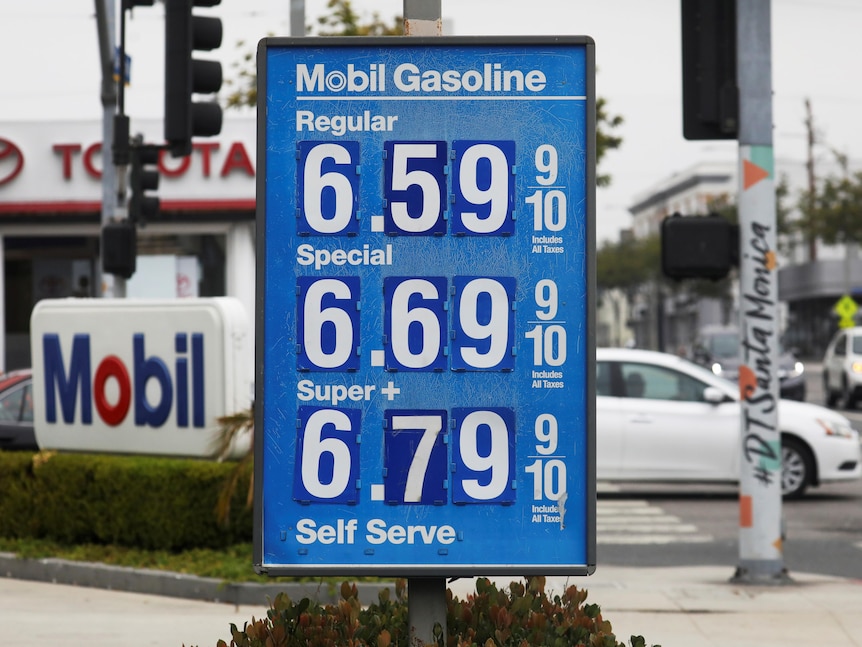 A blue-and-white sign at a Mobil gas station shows prices over the $6.00 mark