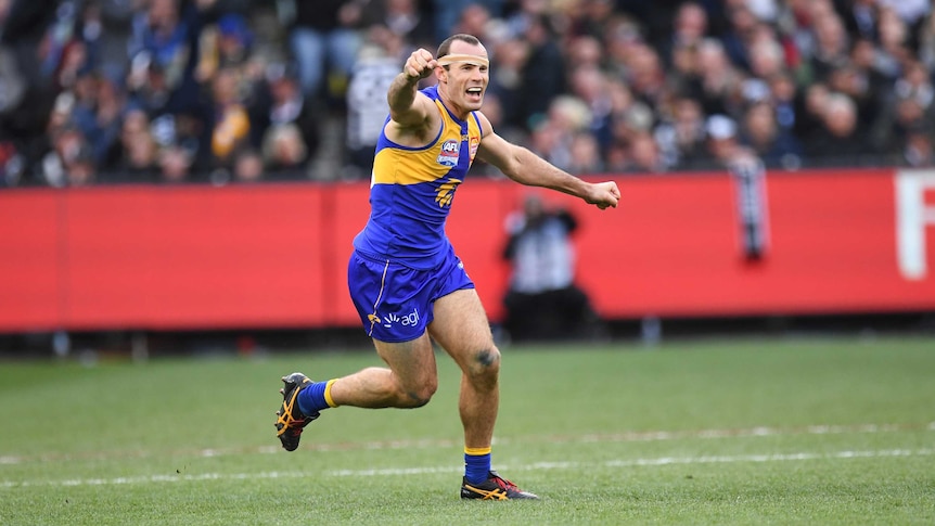 Shannon Hurn raises his right arm to celebrate the West Coast Eagles beating Collingwood in the AFL grand final.
