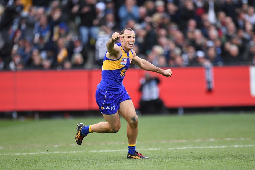 Shannon Hurn raises his right arm to celebrate the West Coast Eagles beating Collingwood in the AFL grand final.