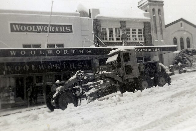 A black and white photo of a snow plow in 1965