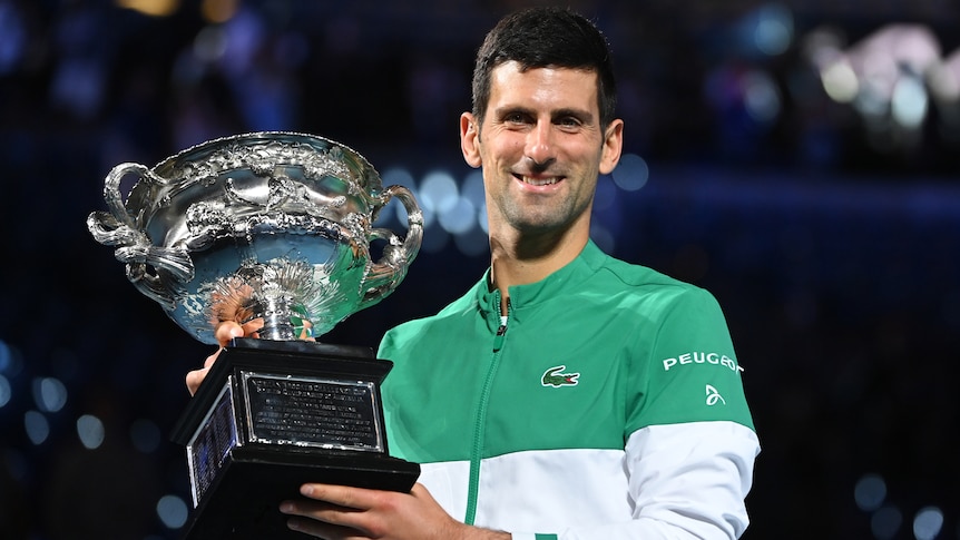 Tennis player smiling with the Australian Open trophy after winning the tournament