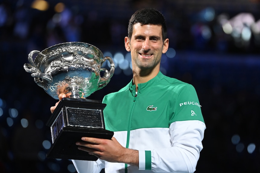 Tennis player smiling with the Australian Open trophy after winning the tournament